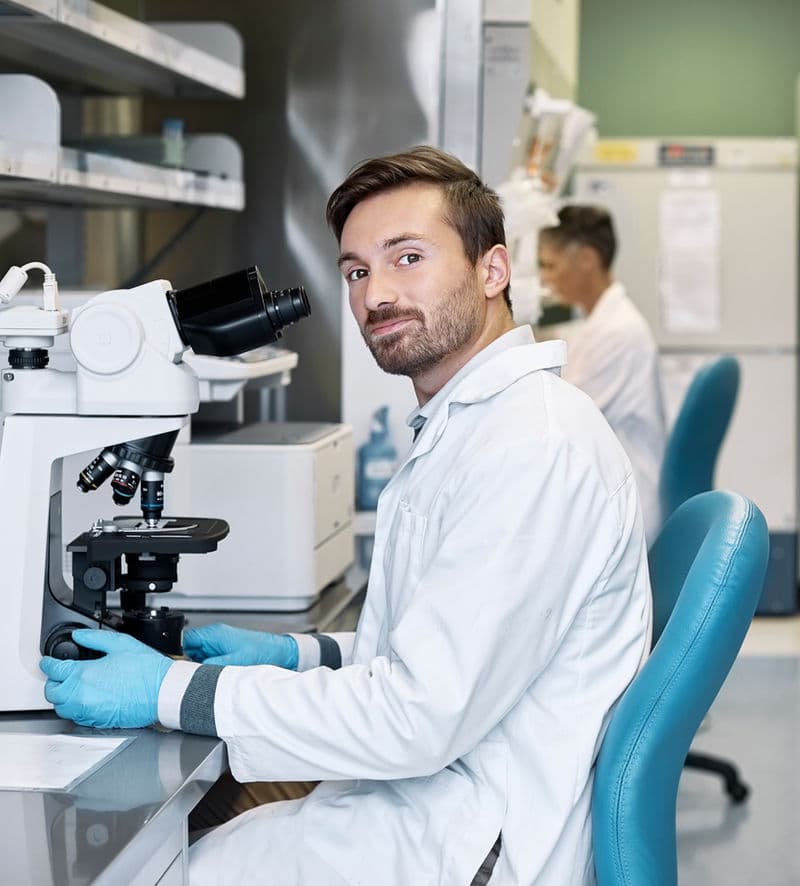 i-GlooAdvance scientist working with a microscope in the laboratory